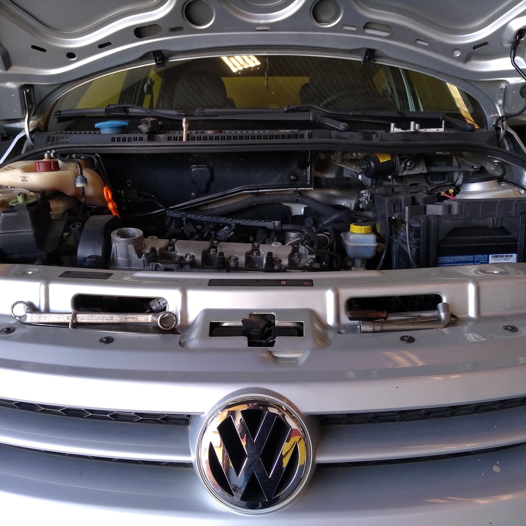 Motor de um Volkswagen em manutenção, com ferramentas sobre a travessa
